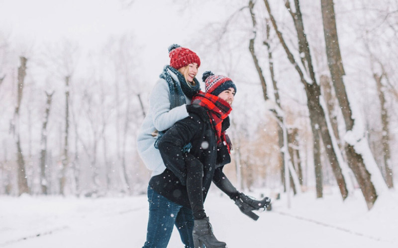 couple posing for a photographer in the snow, Birmingham weddings, September 2024, UK