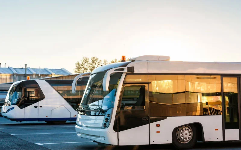A modern coach parked outside Birmingham Airport, ready for group transfer.