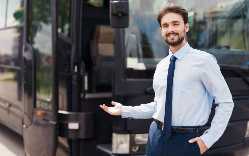 Executive shuttle bus parked outside a Birmingham business park, ready for staff pick-up